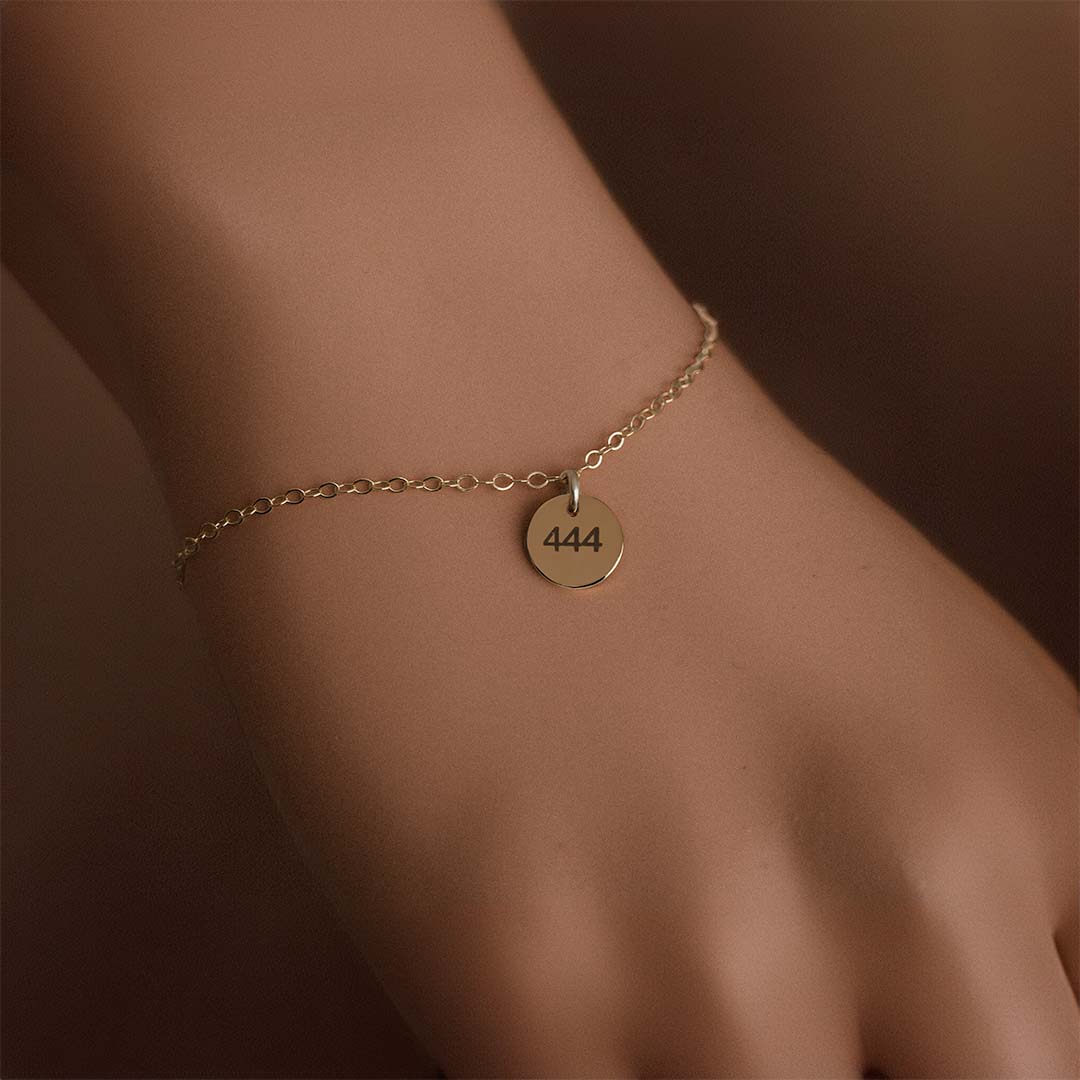 model hand wearing angel number bracelet 444 gold