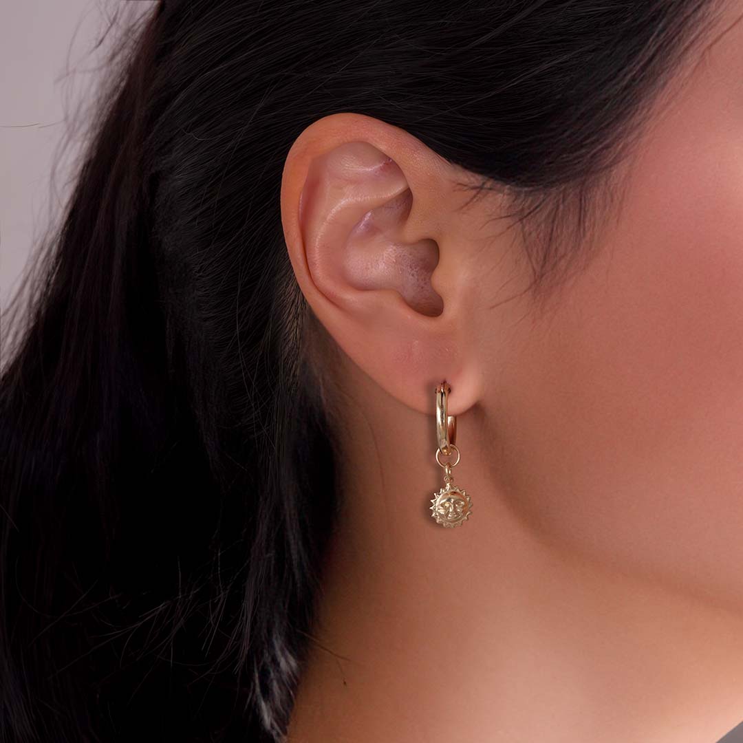 model wearing sun charmed hoop earrings gold