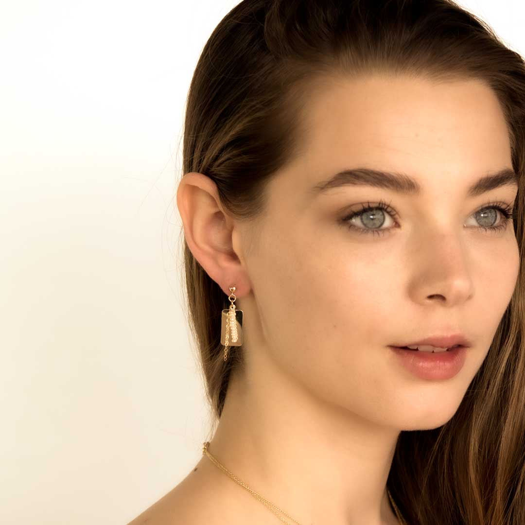 model wearing reflections drop earrings gold and pearl