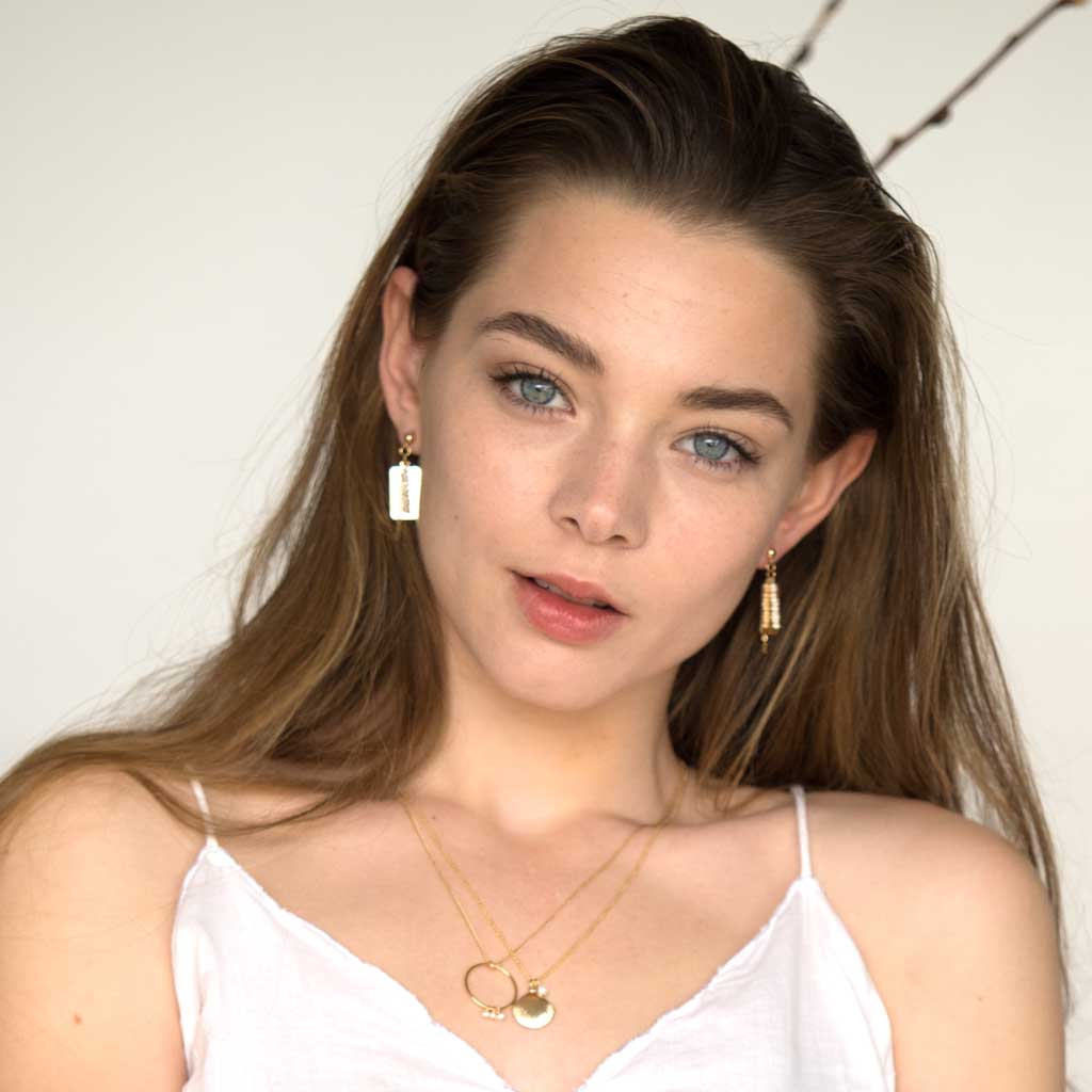 Model wearing Reflections Earrings and Necklaces Gold