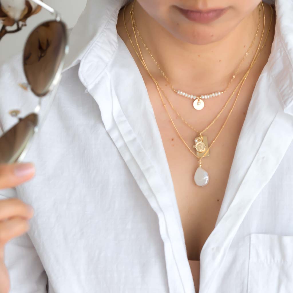 Model wearing Aura Pearl  Reflections and Enchantment Pearl Gold