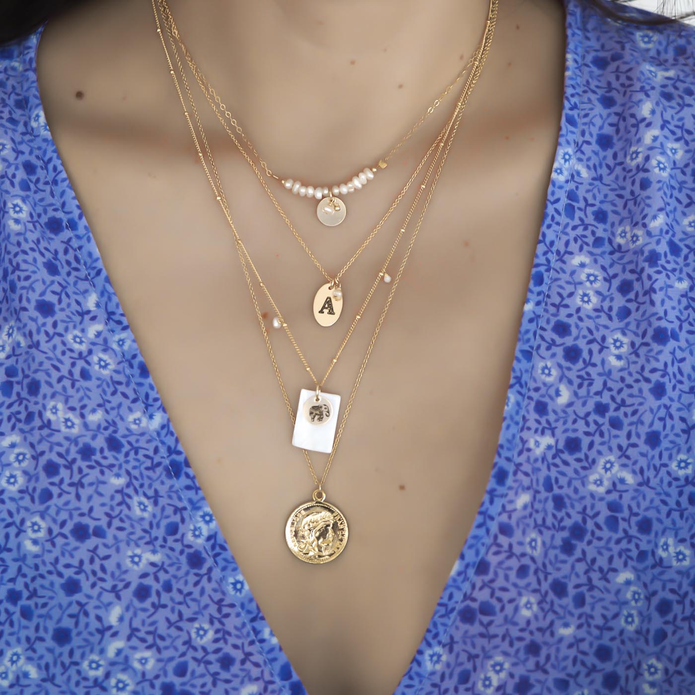 Model wearing Aura, love letter, enchanted elephant and coin necklaces