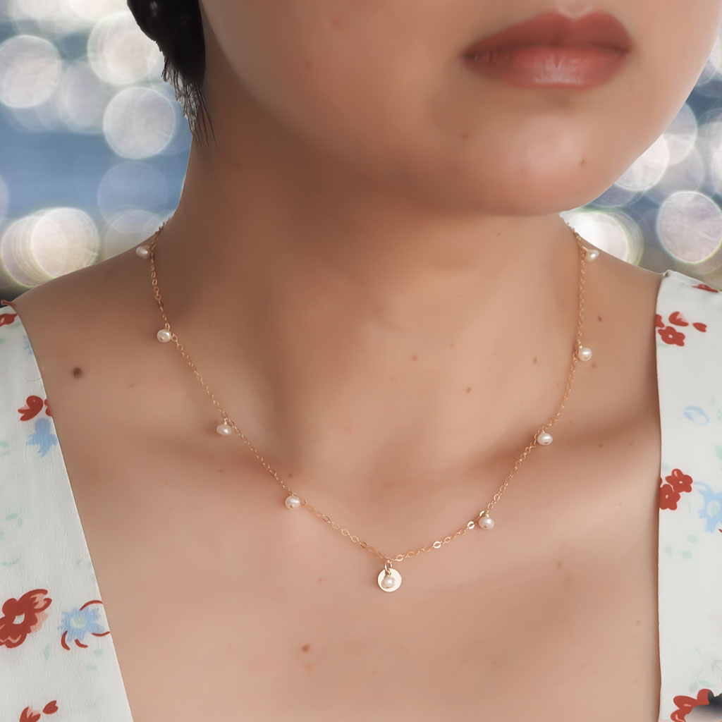 Model wearing Charmed necklace Gold and Pearl