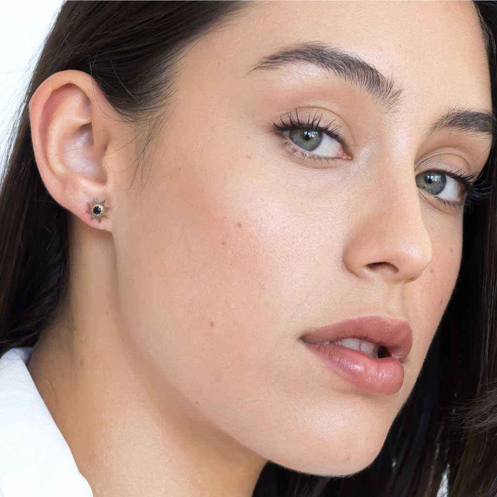 Model wearing Solstice Star earrings rose gold black spinel