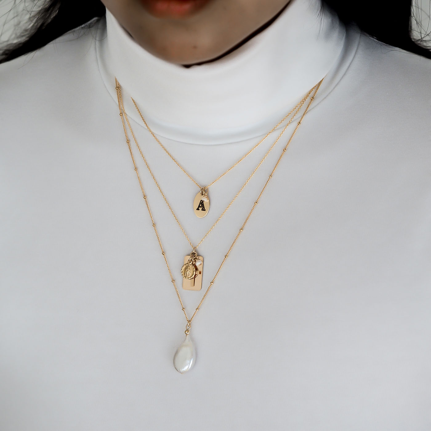 Model wearing Letters, Reflections and Enchantment necklaces