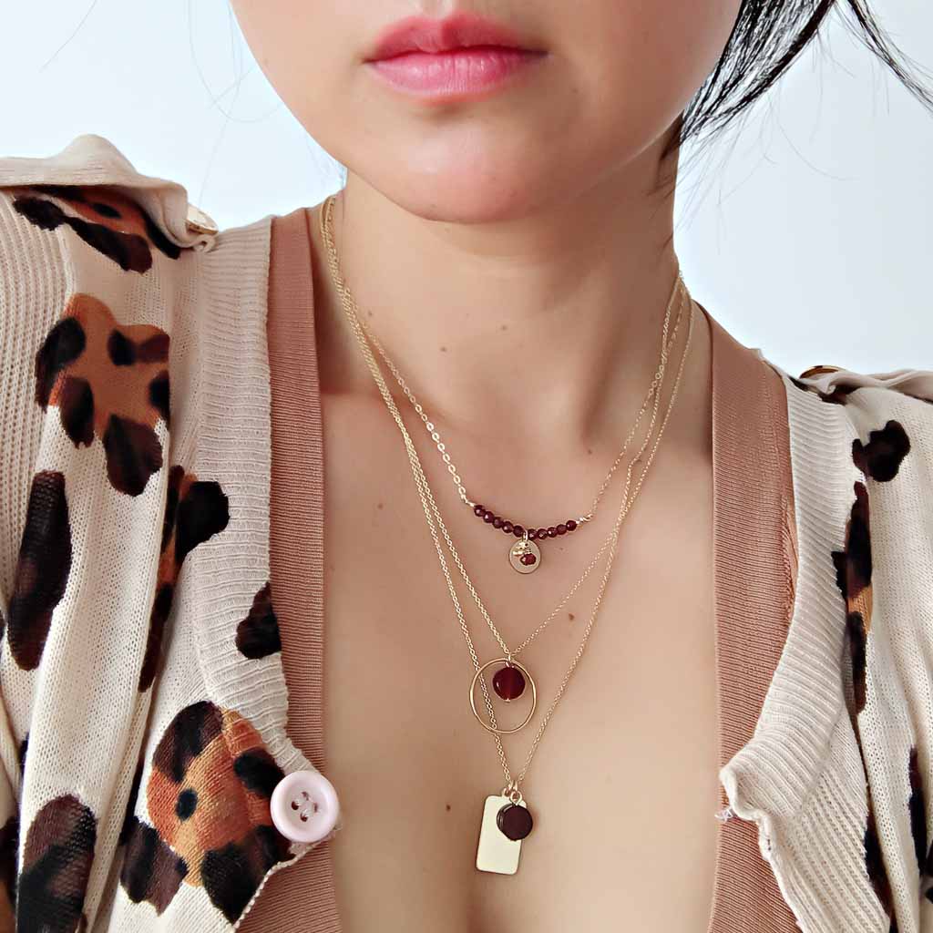 Model wearing Aura, halo sunrise, reflections necklaces goldd and red agate