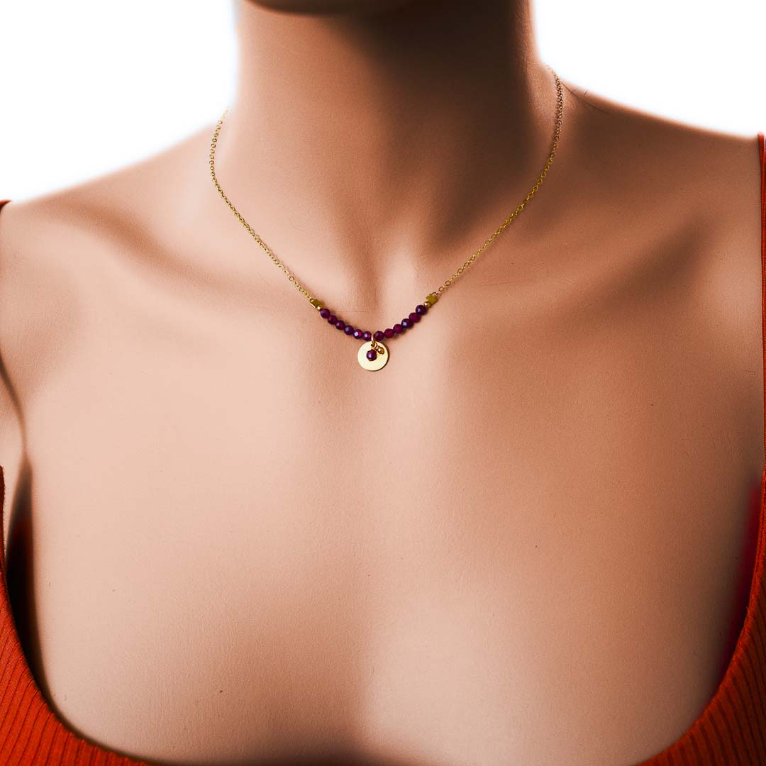 Model wearing Aura necklace gold red garnet