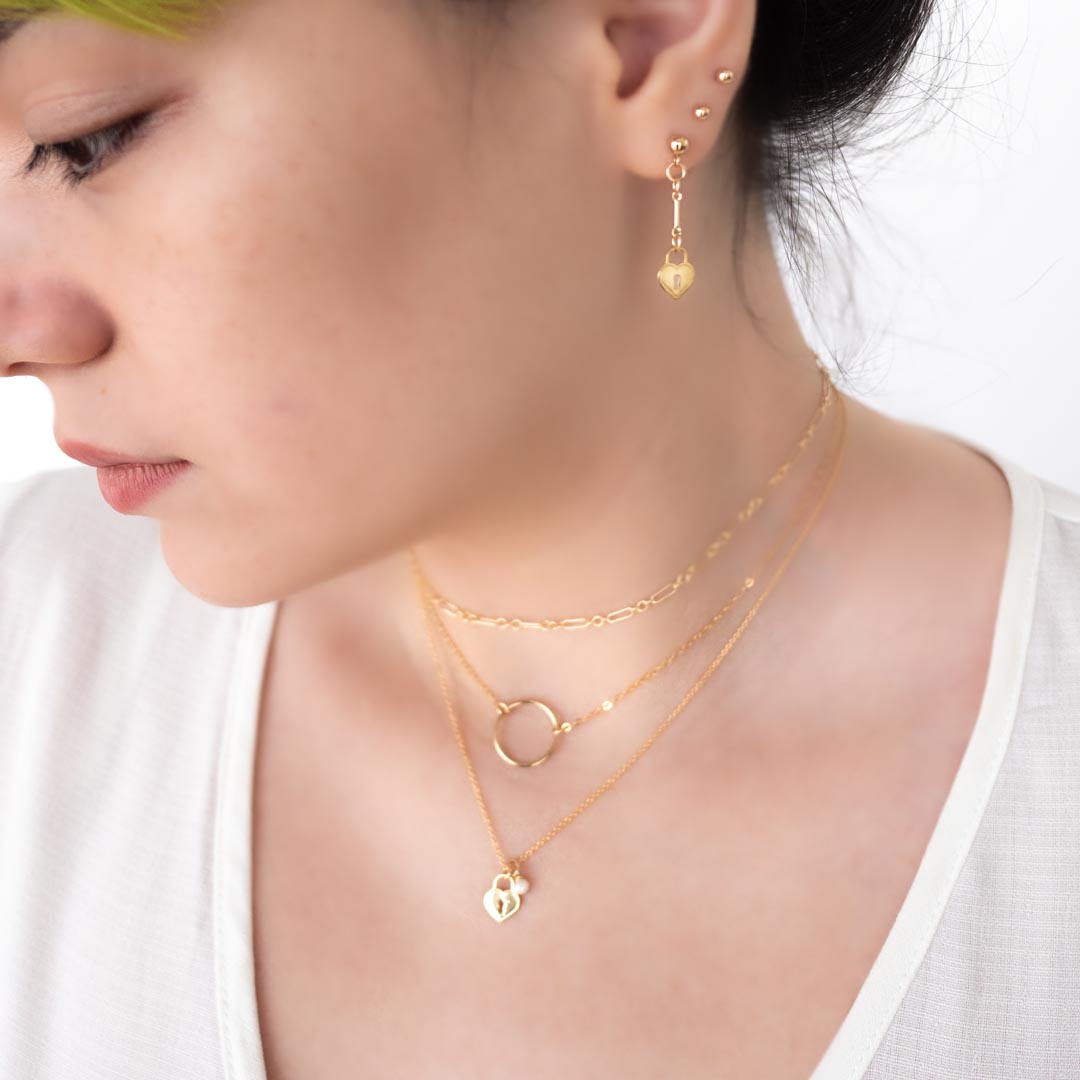 Model wearing Love locket ring chain mail necklaces layered gold