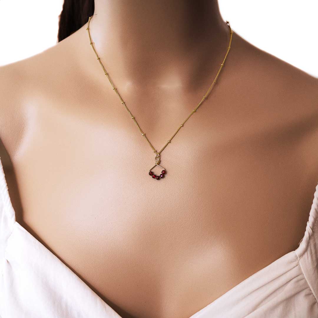 Model wearing Angel 5 14K gold filled necklace with natural red garnet gemstones