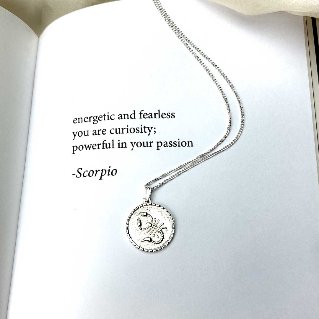 The Scorpio star sign necklace pendant sterling silver jewellery on poetry book