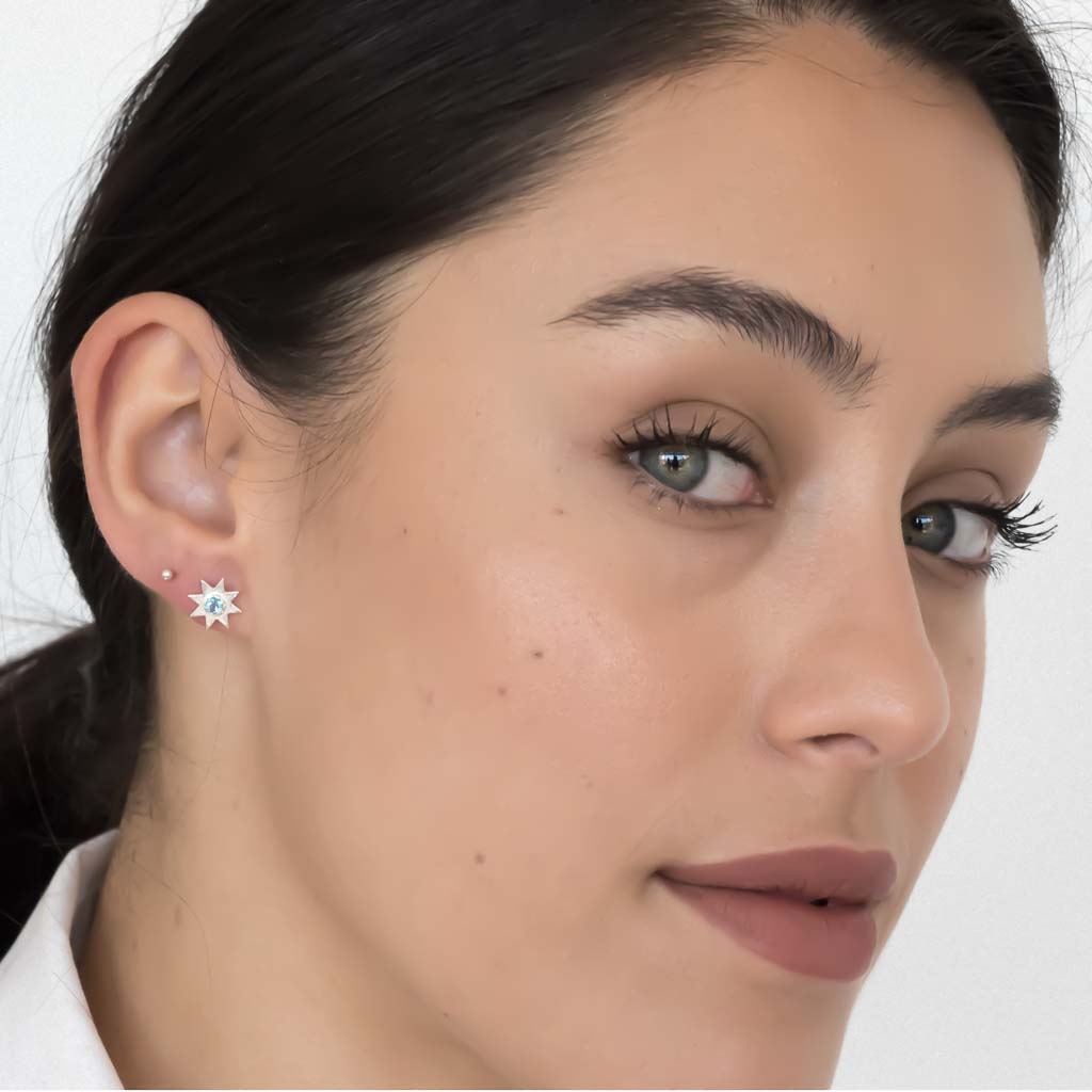 model wearing solstice star earrings silver swiss blue topaz