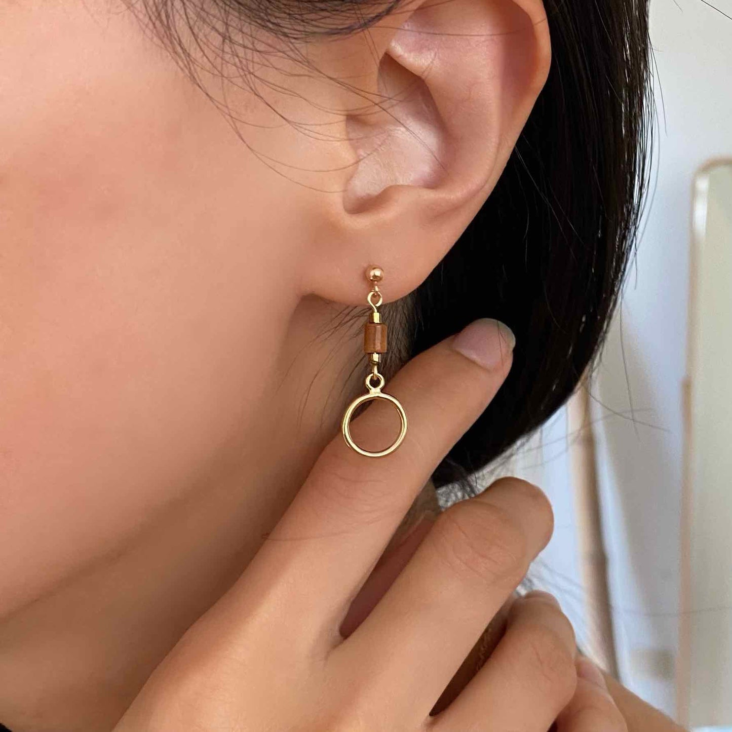 model wearing Cinnamon Scroll Drop Earrings - Gold and Jasper