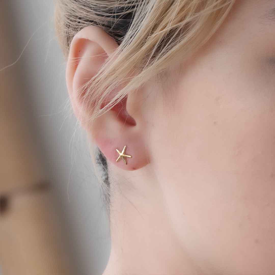 model wearing mermaid starfish stud earrings gold