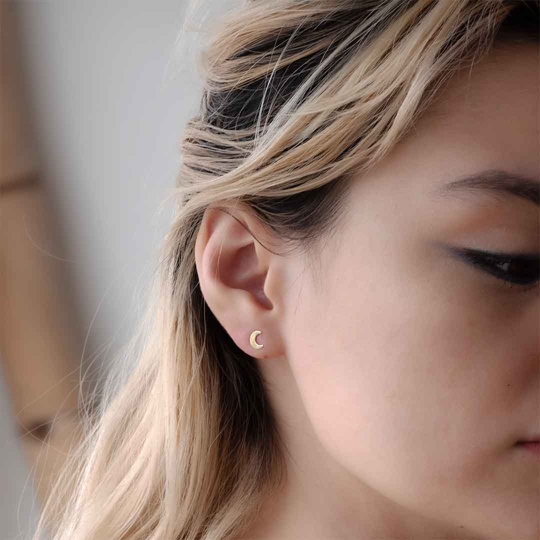 model wearing new moon stud earrings gold