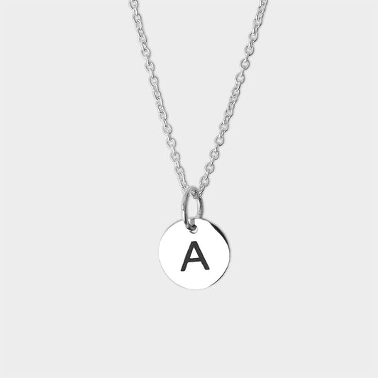 A silver initial necklace with a round silver disc pendant engraved with the black capital letter 'A'