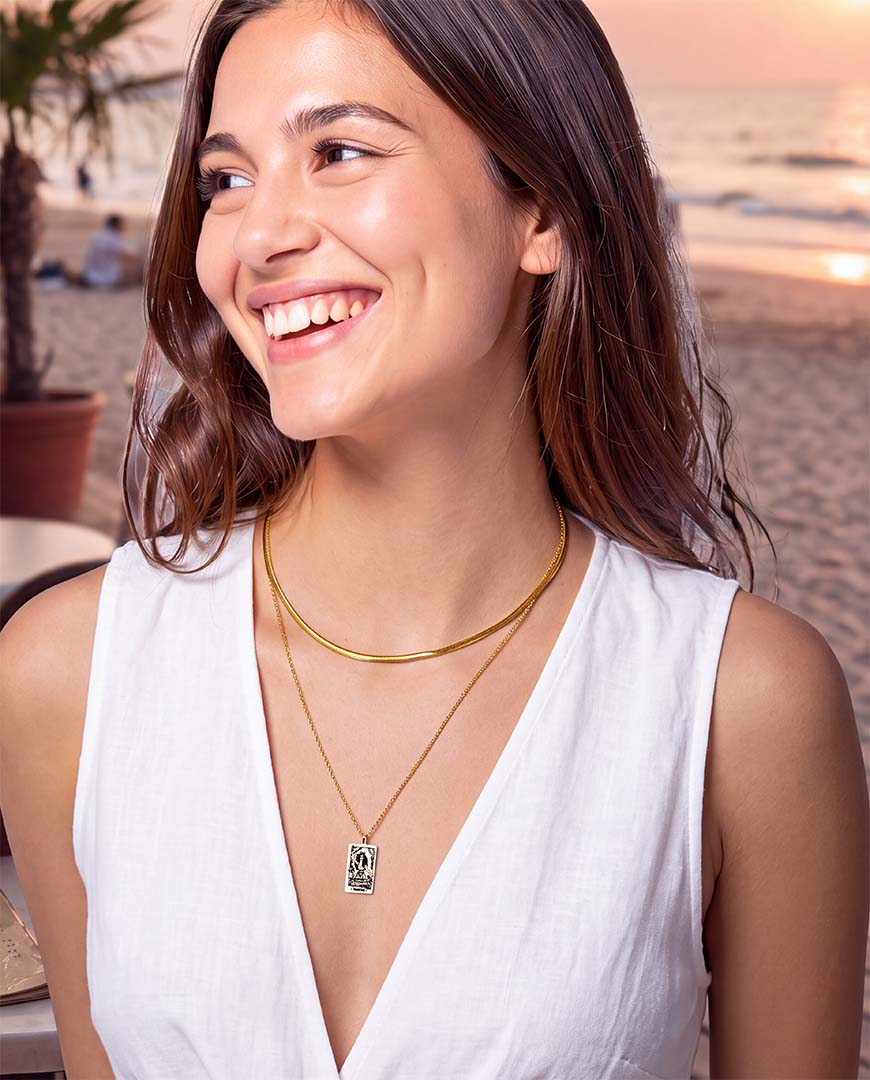 Model wearing Tarot Magician necklace and snake chain in gold white dress at cafe on Beach in Bali