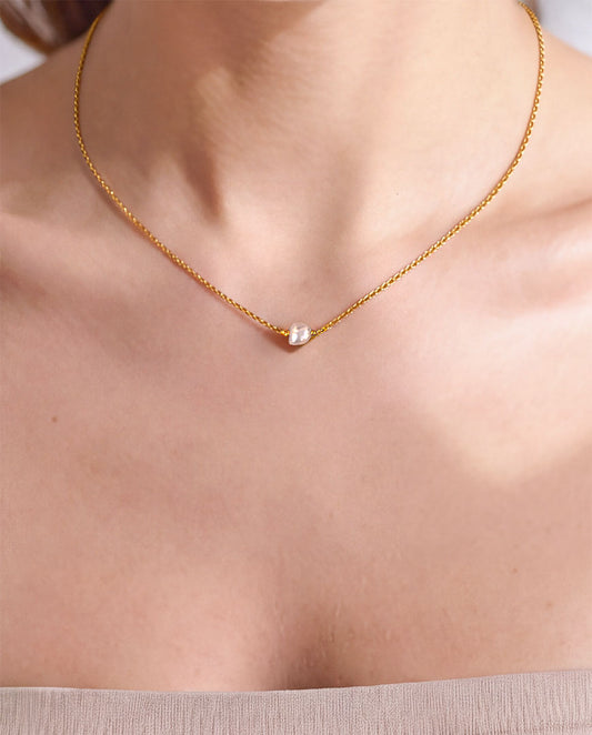 model wearing single pearl necklace with 14k gold filled chain and freshwater pearl closeup on chest
