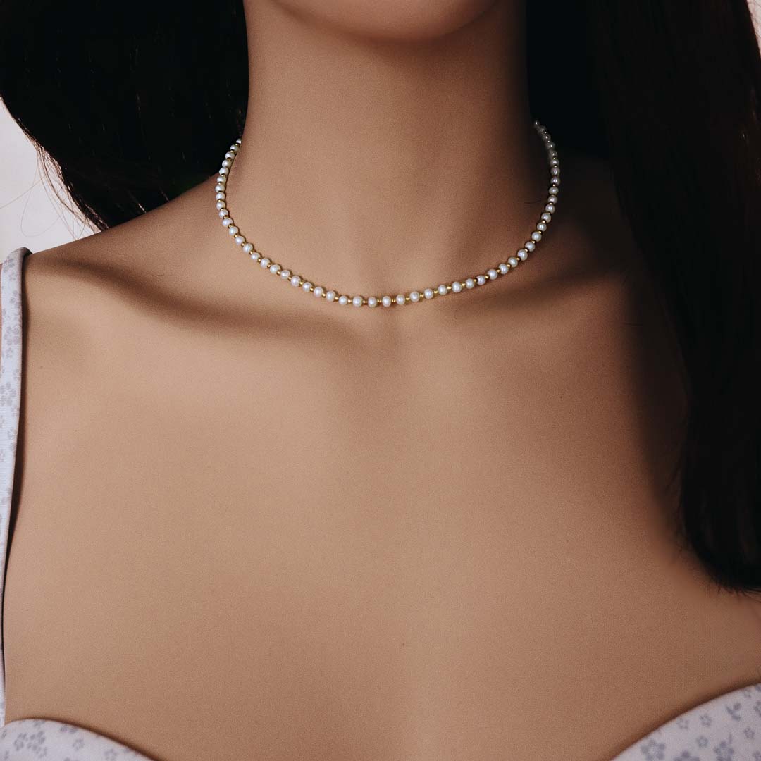 Model wearing Grace necklace gold pearl