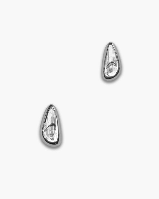 Teardrop Stud Earrings - Silver. A pair of polished silver teardrop-shaped stud earrings with a faceted, textured surface, displayed on a clean white background.