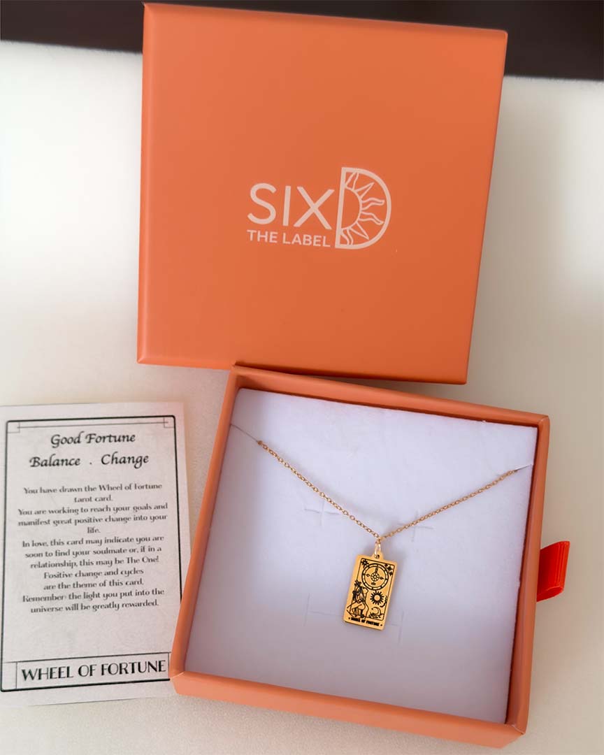 Wheel of Fortune Tarot necklace in gold with packaging and meaning card