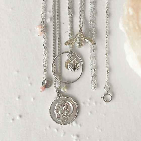 silver necklaces celestial elements bee halos flatlay