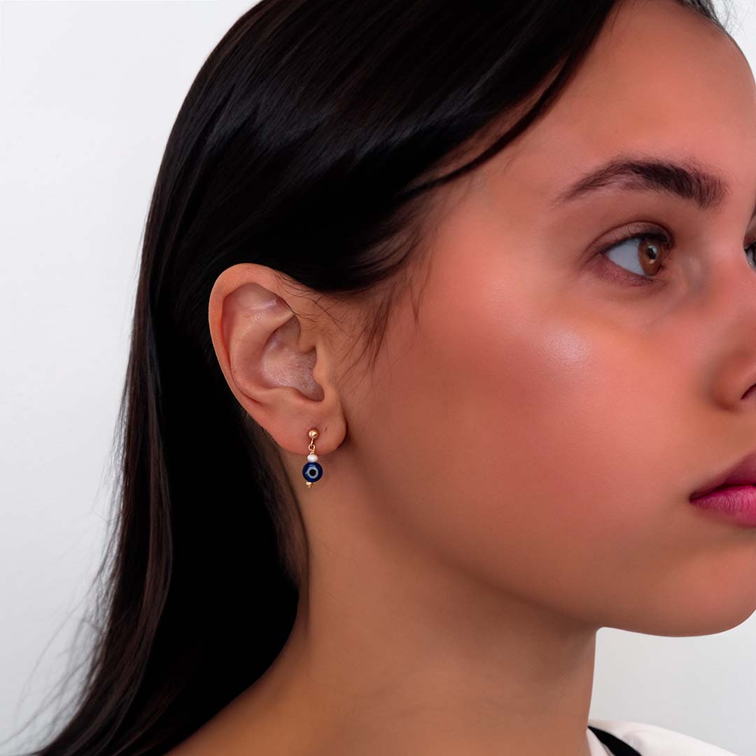 model wearing evil eye drop earrings gold