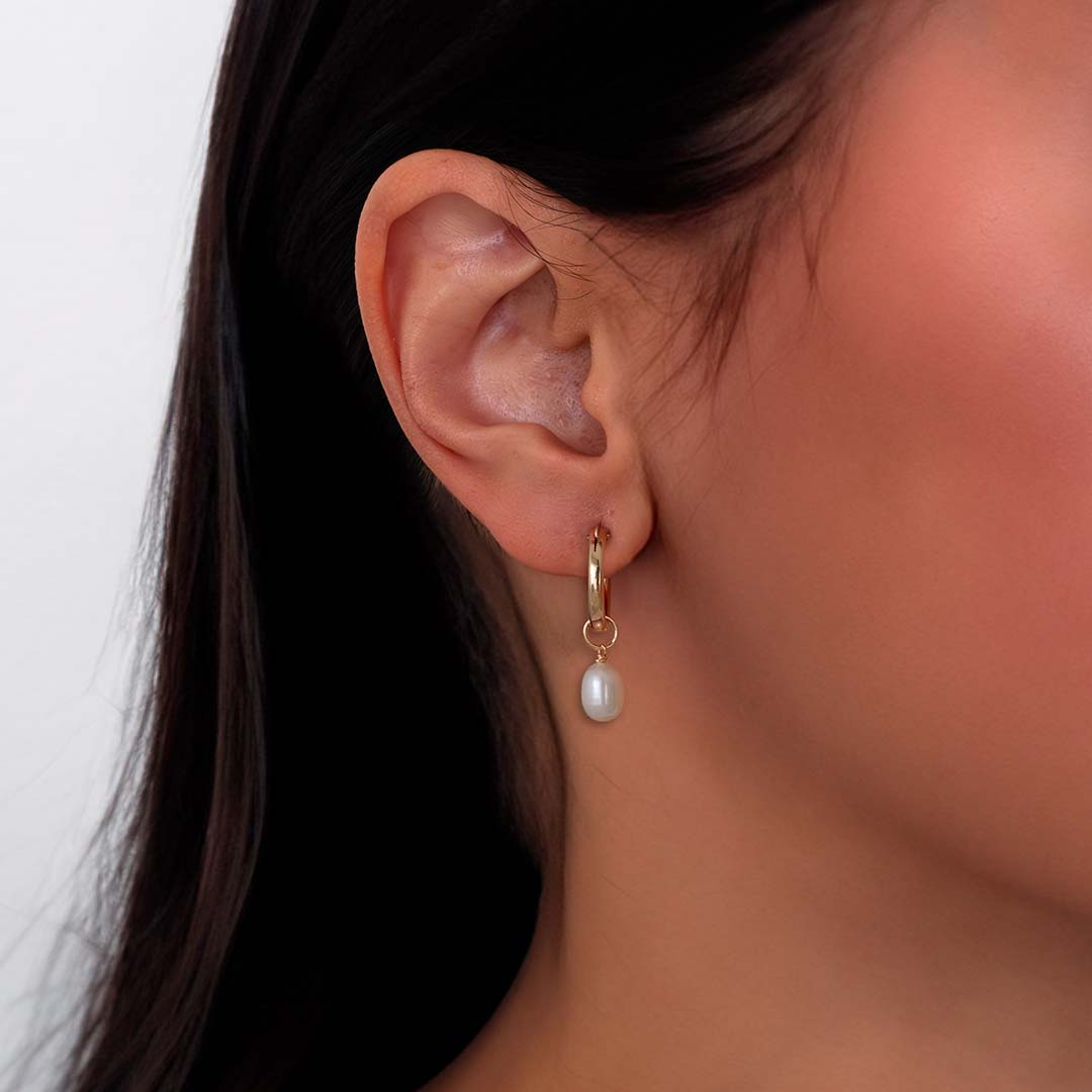 model wearing pearl charmed hoop earrings gold