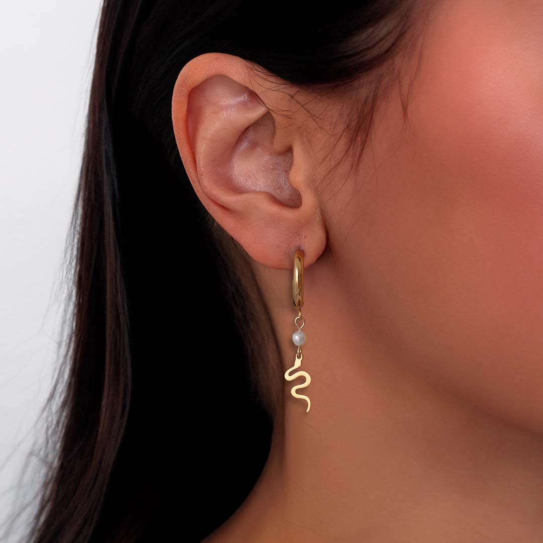 model wearing serpent charmed hoop earrings gold