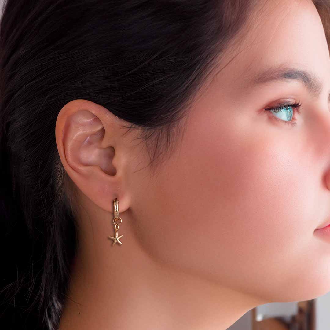 model wearing starfish charmed hoop earrings gold
