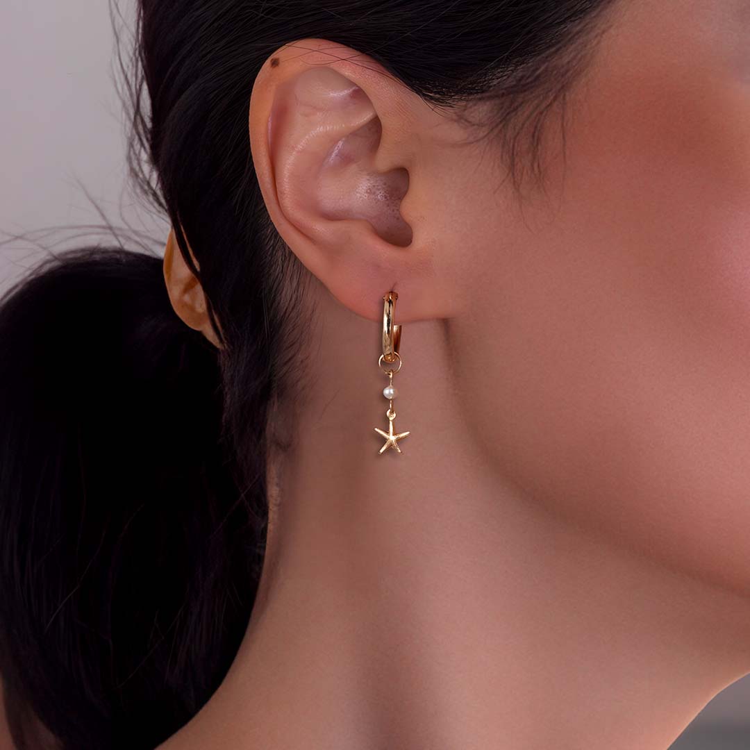 model wearing starfish charmed hoop earrings gold pearl