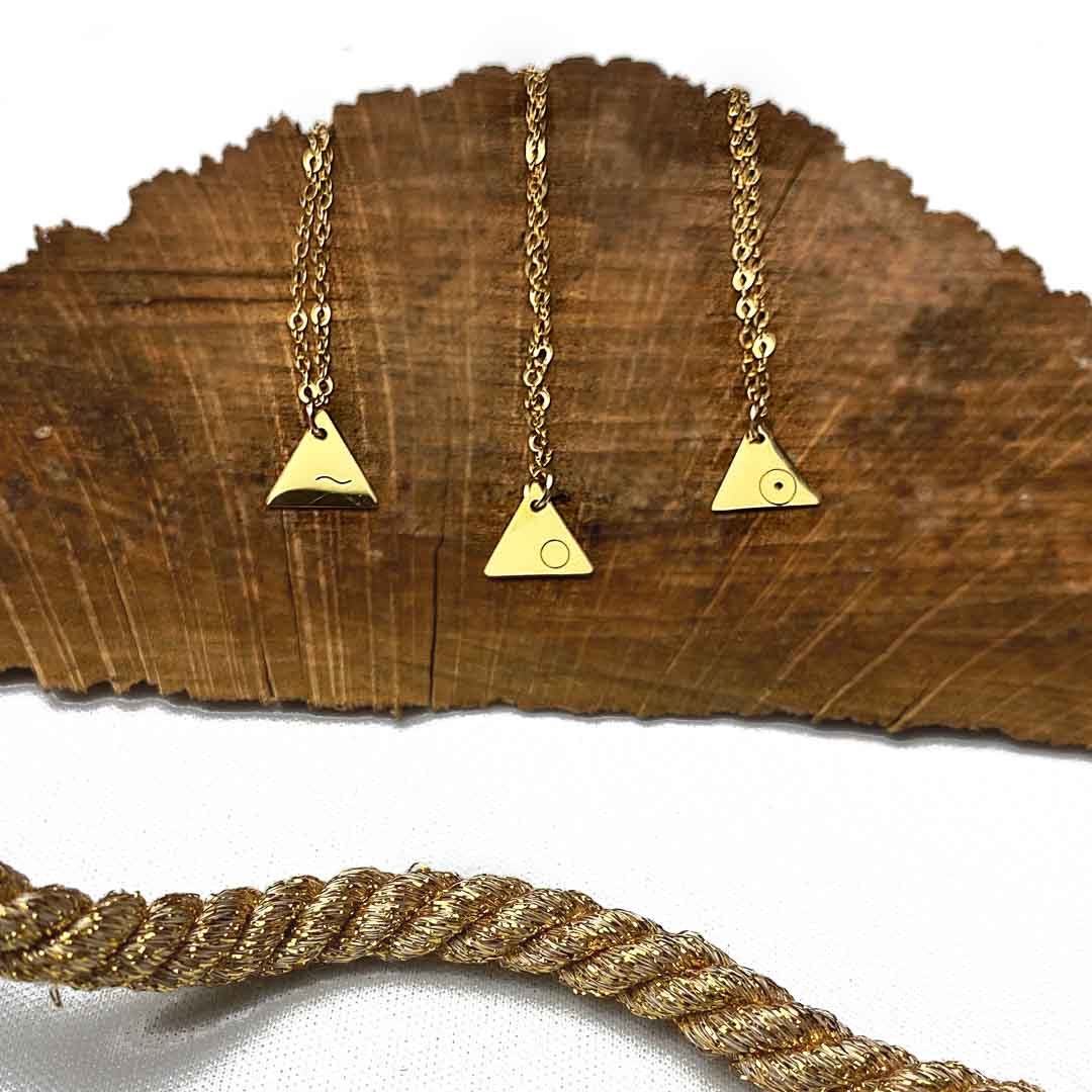 3 points air, fire, water necklace pendants 14K gold filled jewellery flatlay on bark