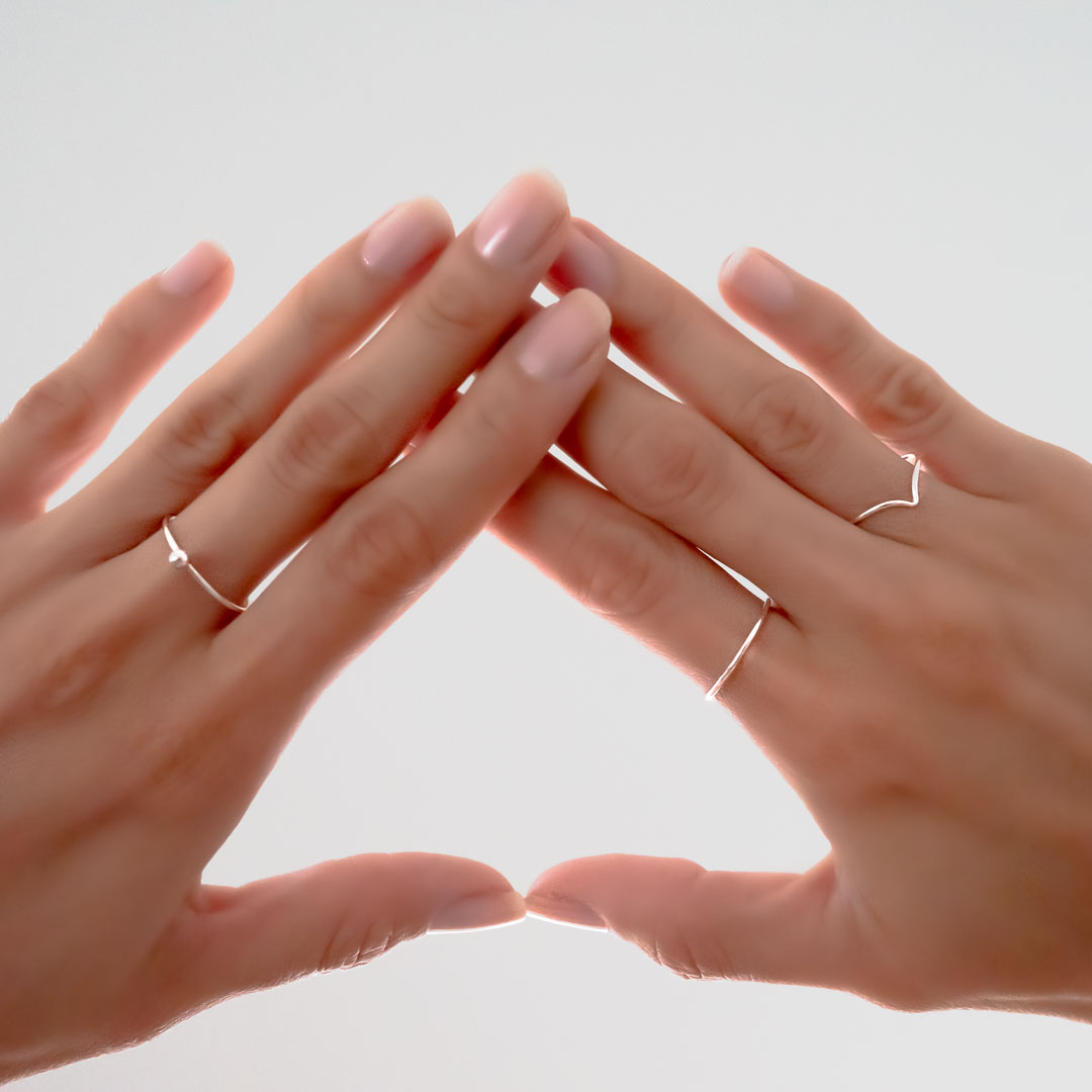 Hands wearing perfect circle dot wishbone rings silver