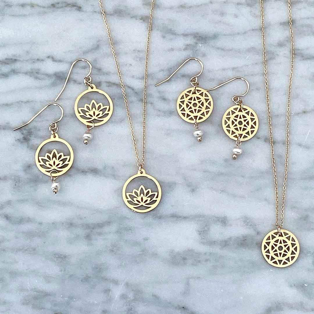 Lotus and Dandelion hook earrings and necklace flatlay gold