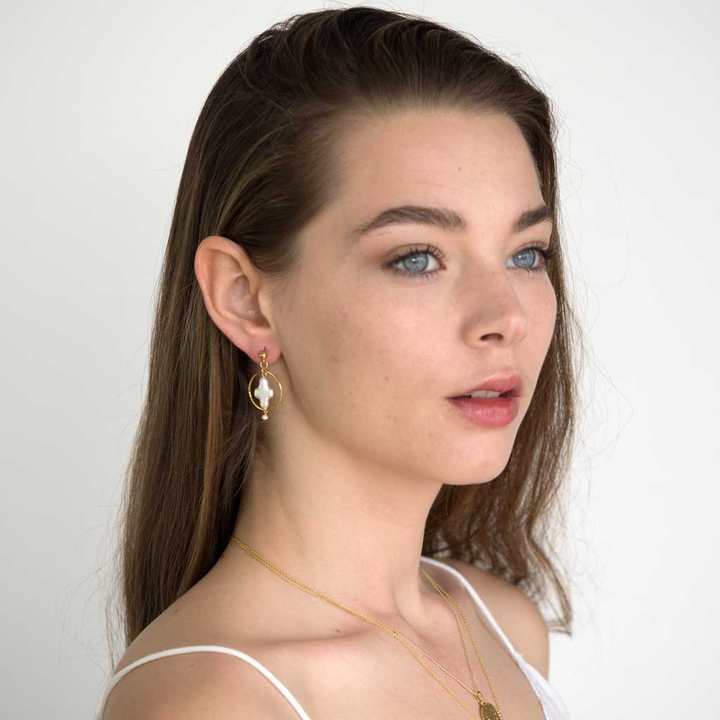Model wearing Halo Cross earrings gold and pearl