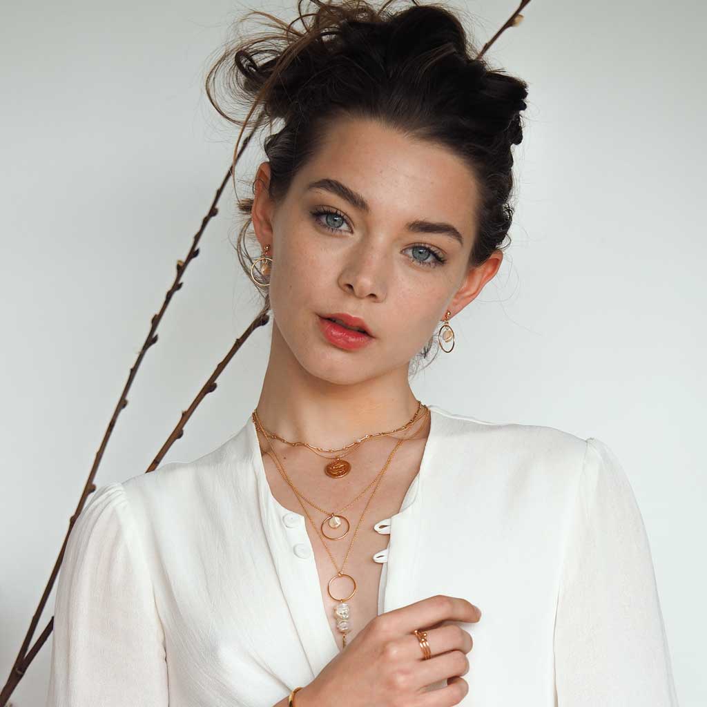 Model wearing Moonglow earrings and necklace gold styled