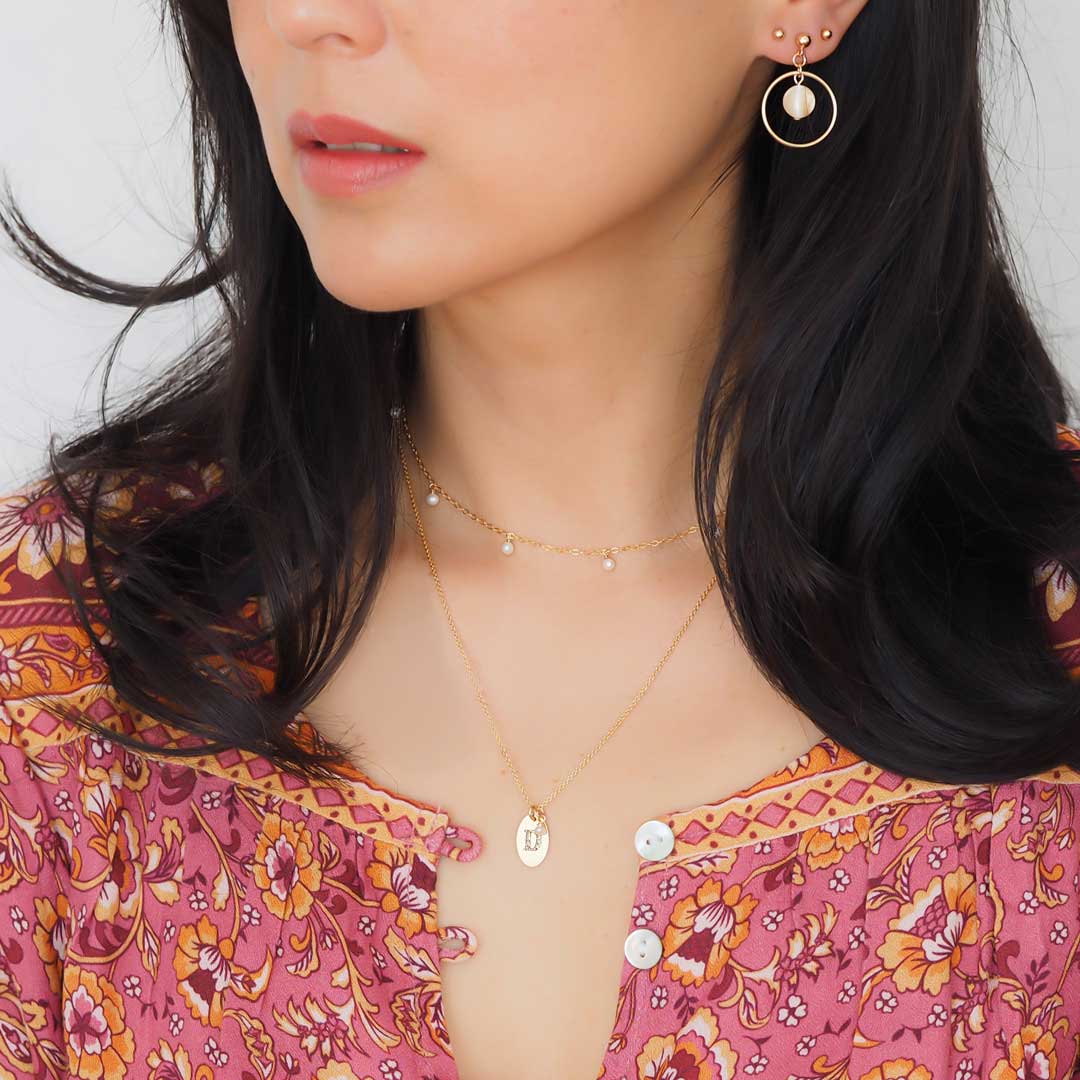Model wearing Halo Moonglow earrings, charmed and loveletter necklaces
