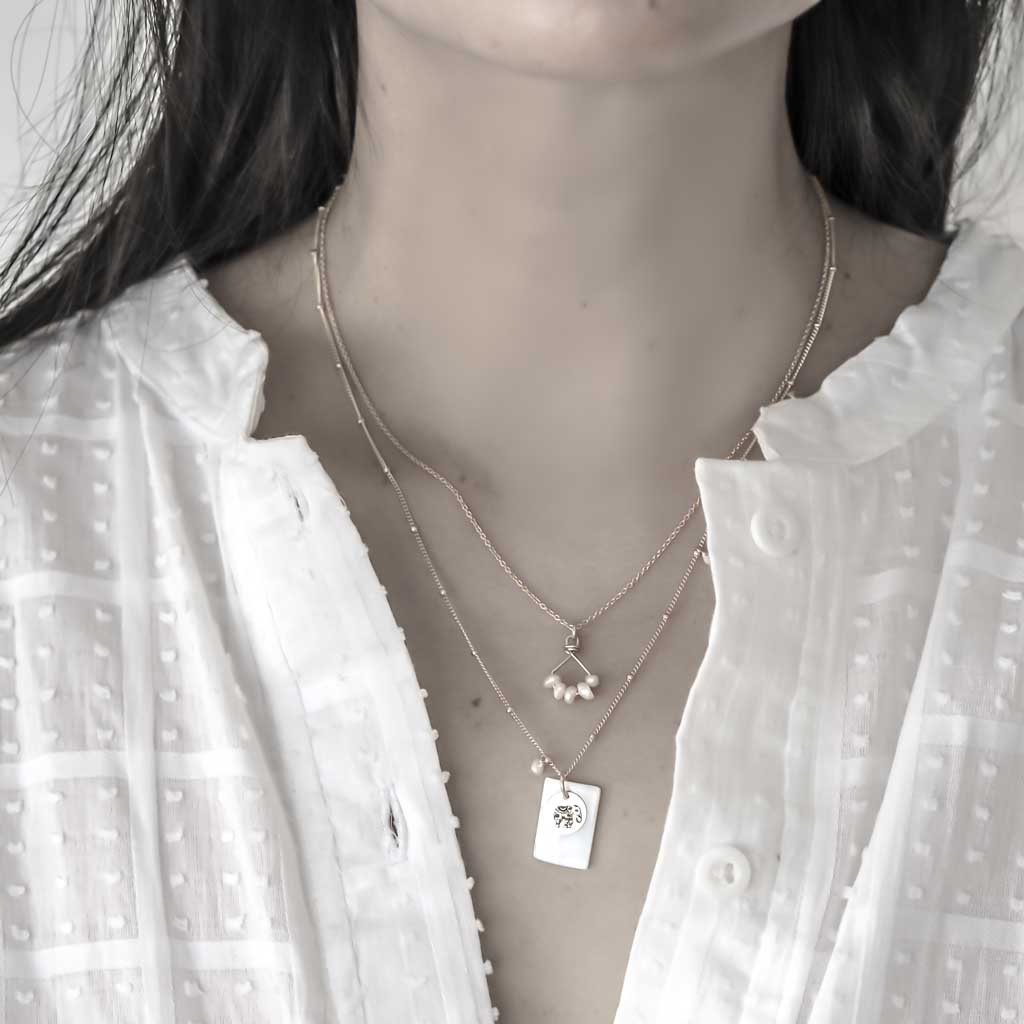 Model wearing Angle 5 and Enchanted Elephant necklaces gold and Pearl