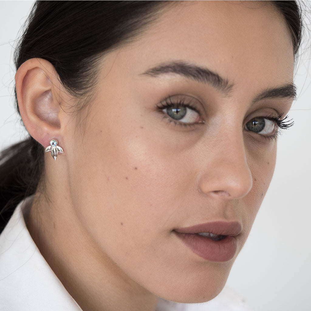 Model wearing Bloom earrings silver swiss blue topaz