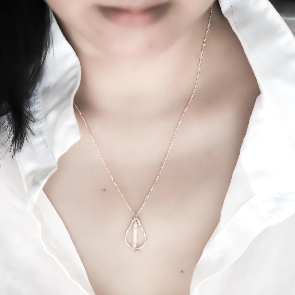 Model wearing Candle Flame Necklace Gold and Pearl