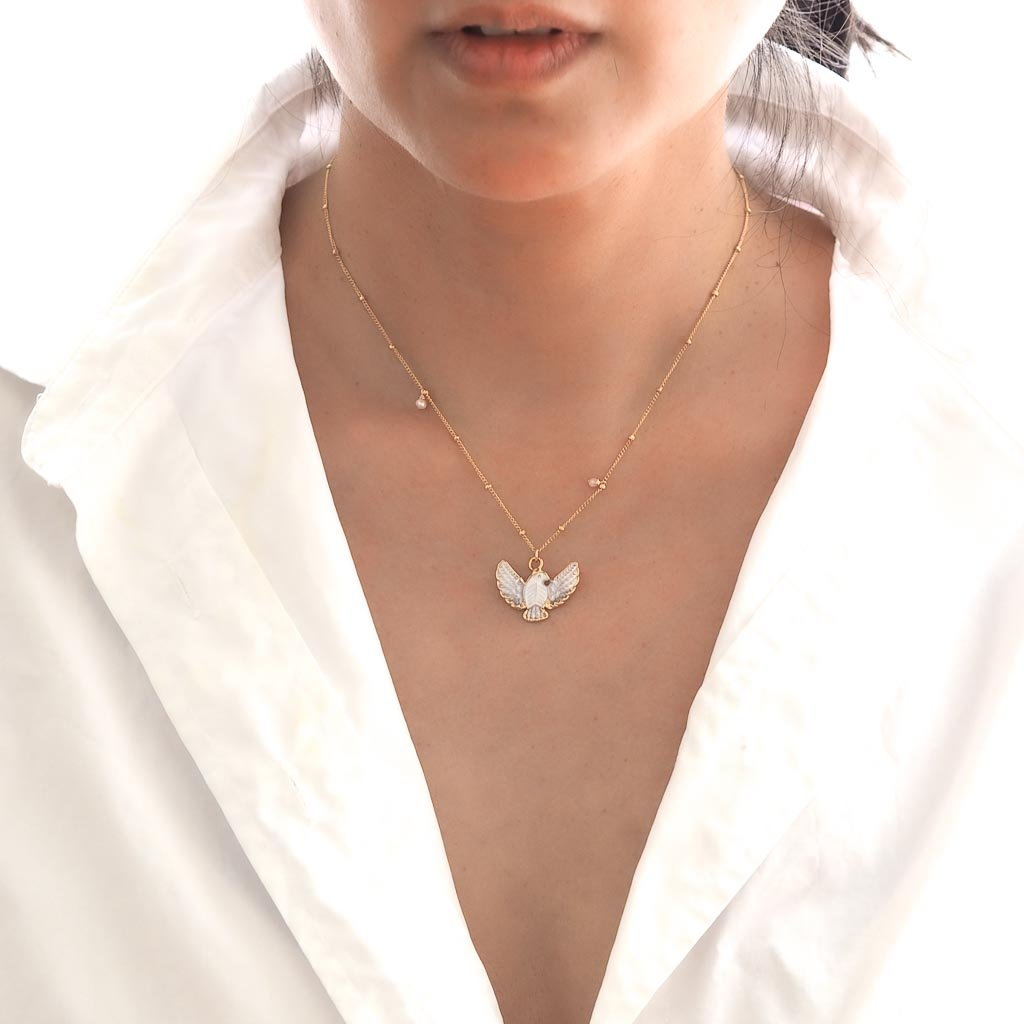 Model wearing Dove Necklace Gold and Mother of Pearl