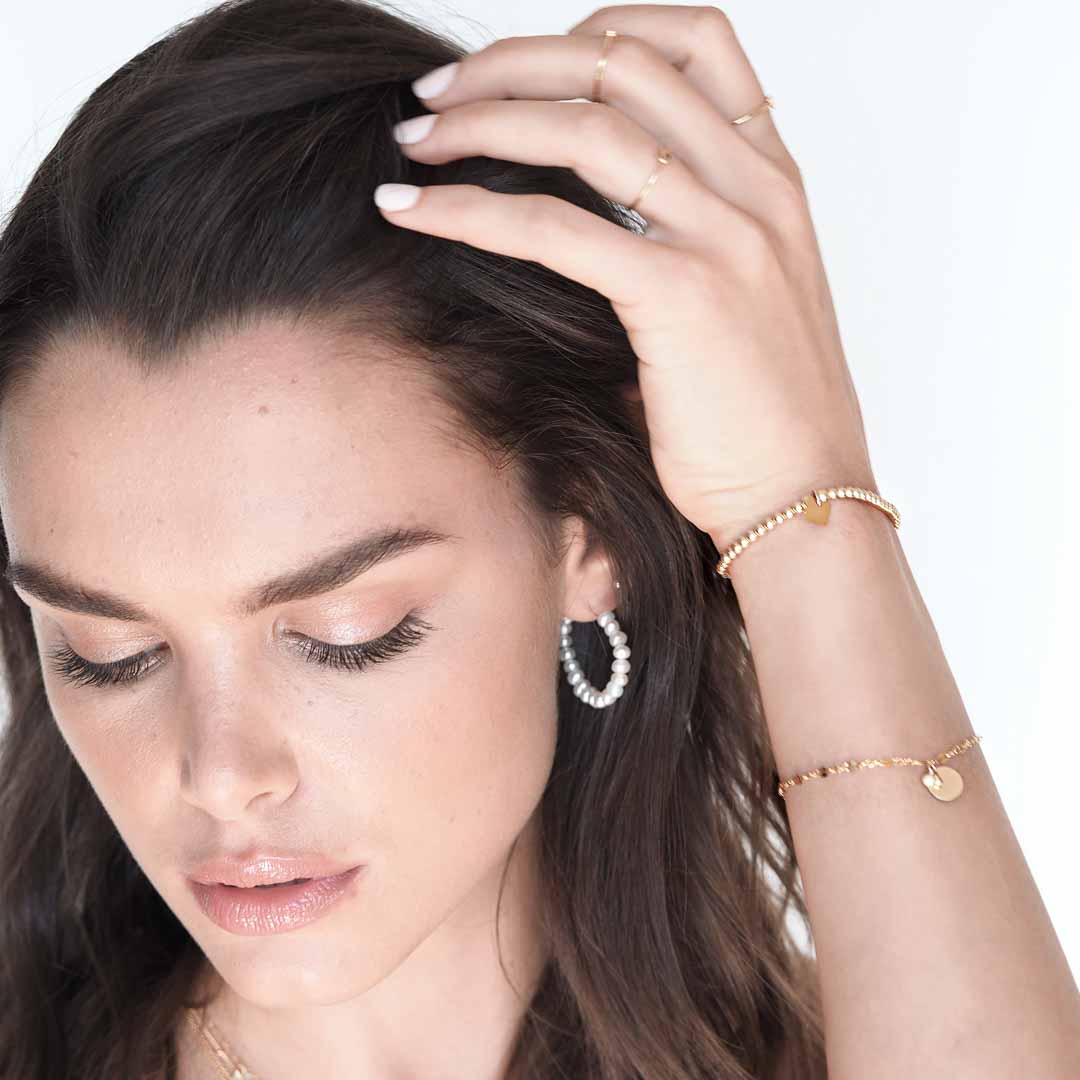 Model wearing heavenly glow earrings gold and pearl