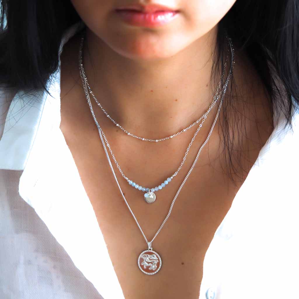 Model wearing Aries and Aura necklaces silver and aquamarine styled 2