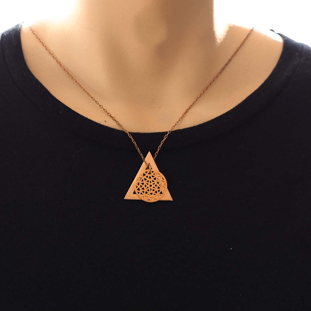 Model wearing dandelion and delta glyph pendant rose gold short chain