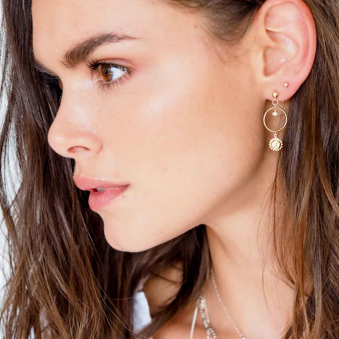 Model wearing Halo Sun earrings gold and pearl