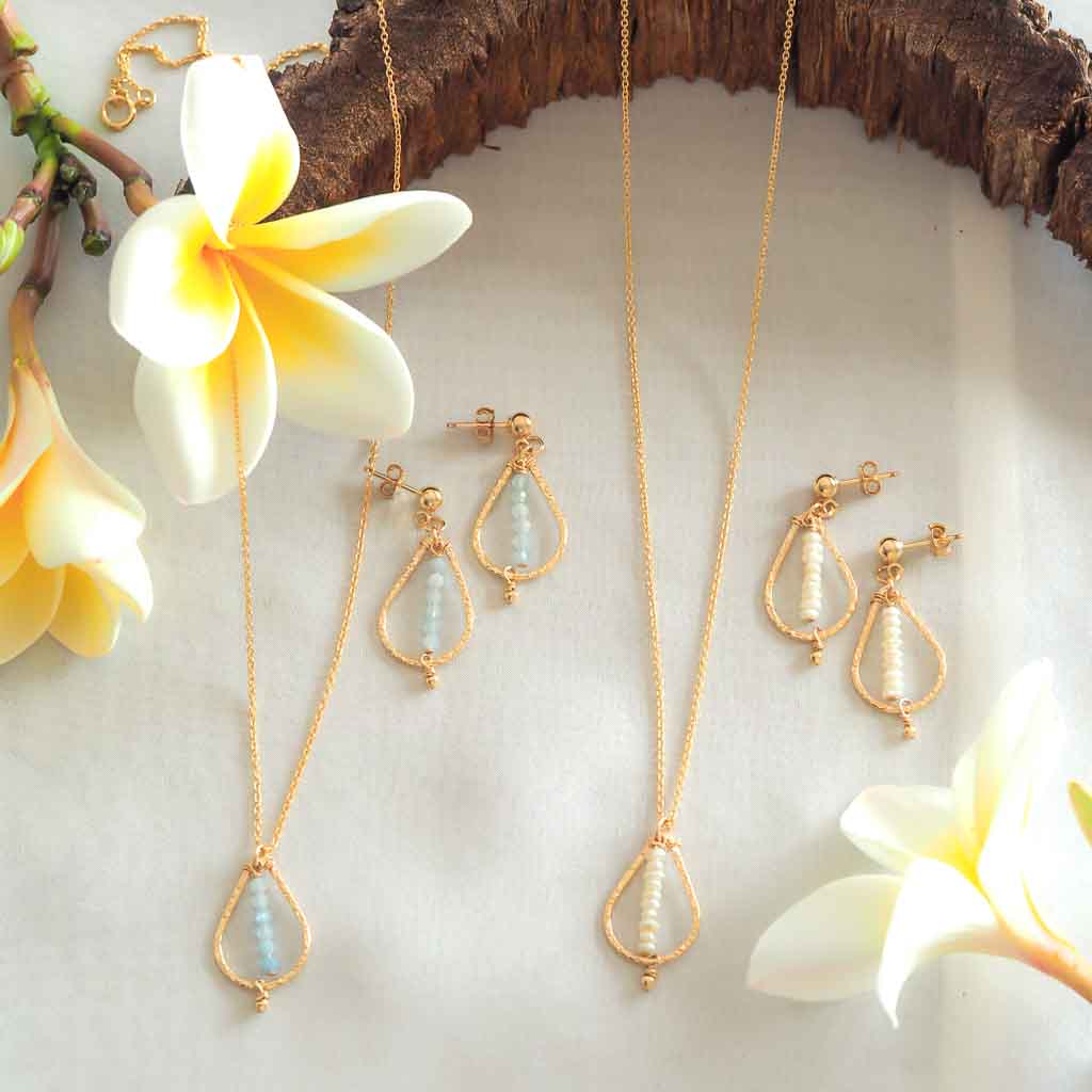 Candle Flame Earrings and Necklaces Gold Pearl and Aquamarine flatlay