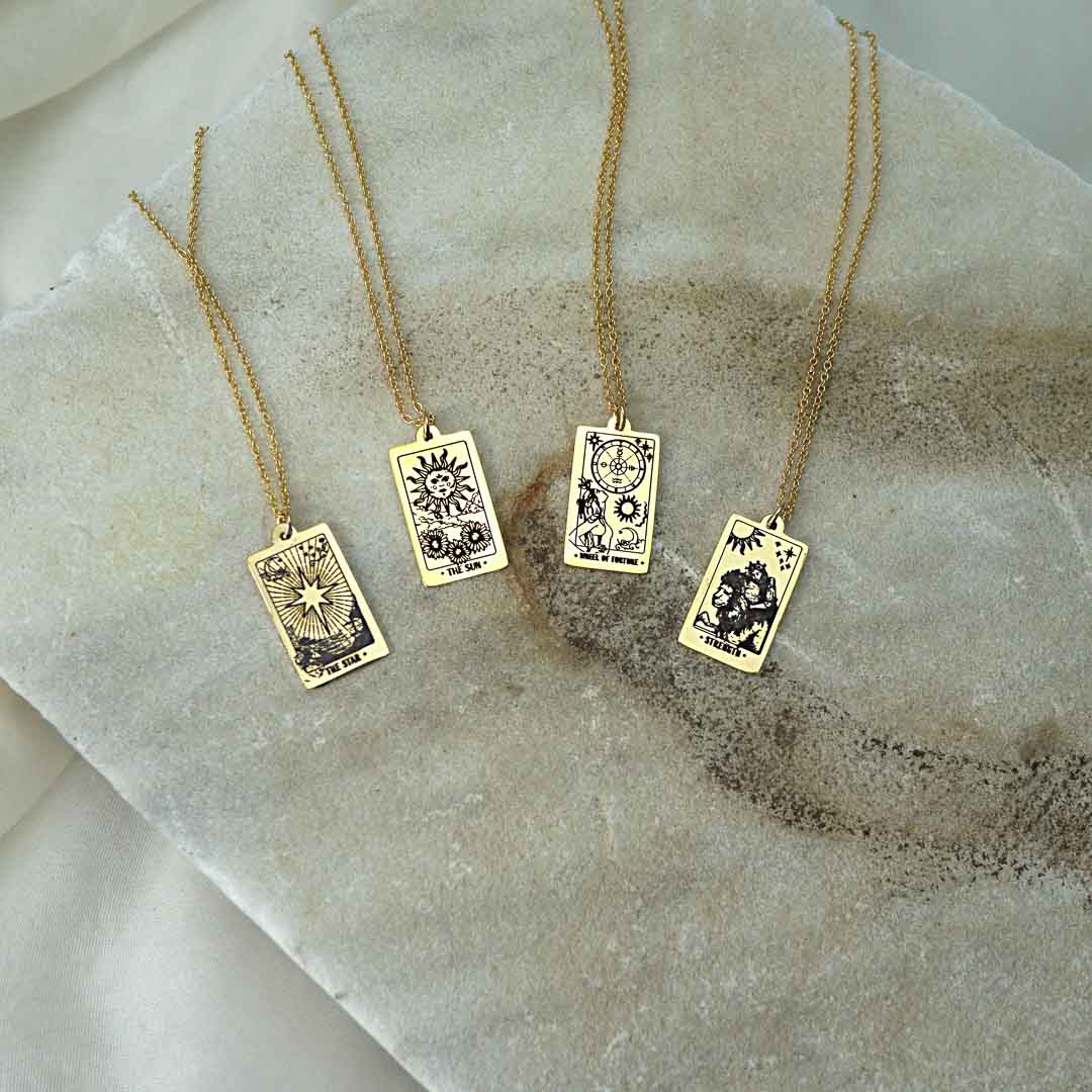 Star, Sun, Wheel of  Fortune and Strength Tarot necklace pendants 14K gold filled jewellery flatlay 