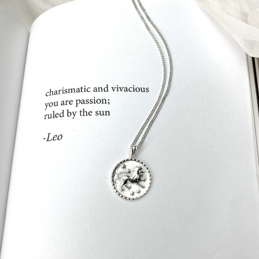 Leo star sign necklace pendant sterling silver jewellery on poetry book
