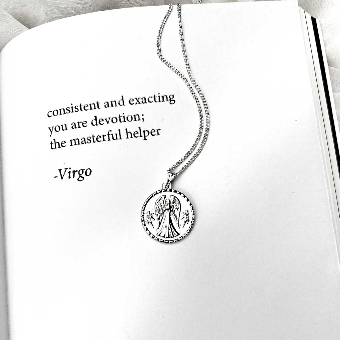 Virgo  star sign necklace pendant sterling silver jewellery on book with poetry