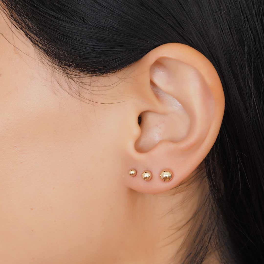 Model wearing 3 perfect dot earrings closeup