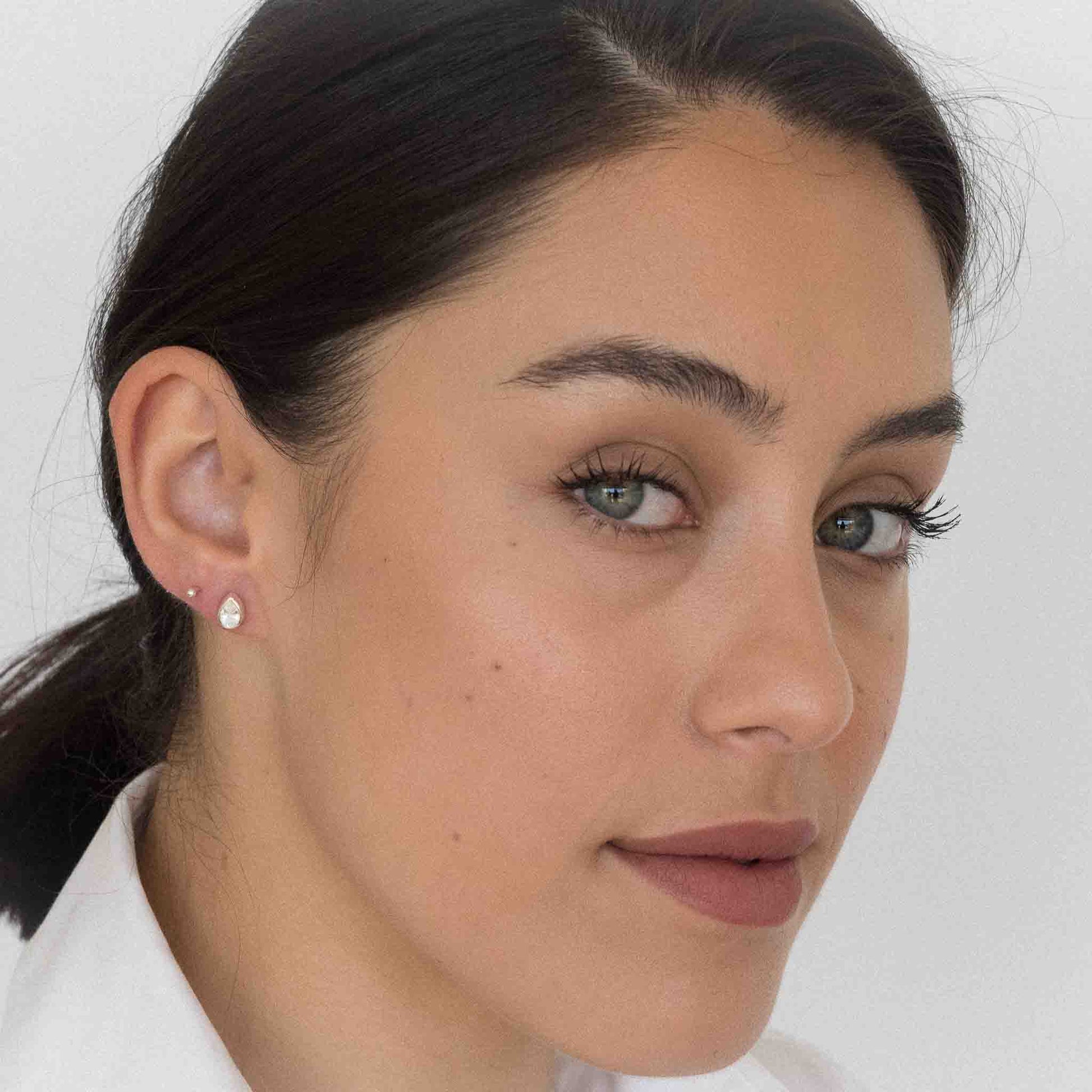 model wearing teardrop stud earrings silver clear quartz